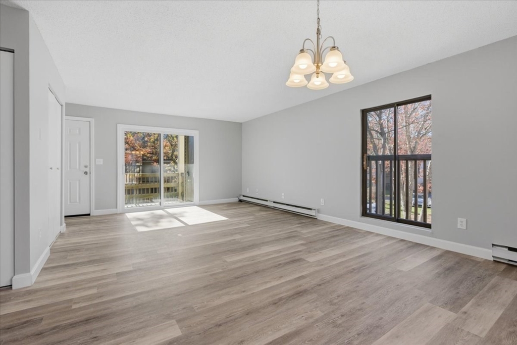 800 Bearses Way, Unit 2SB Barnstable, MA 02601 - Photo 14 of 40 an empty room with wooden floor cabinet and windows