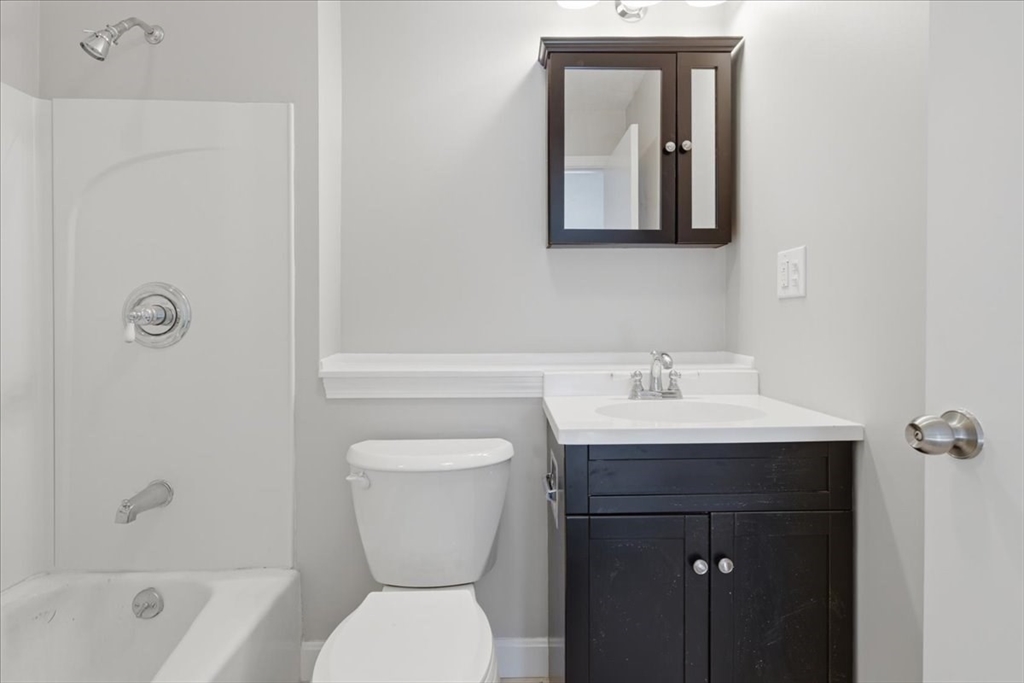 800 Bearses Way, Unit 2SB Barnstable, MA 02601 - Photo 28 of 40 a bathroom with a toilet a sink and mirror
