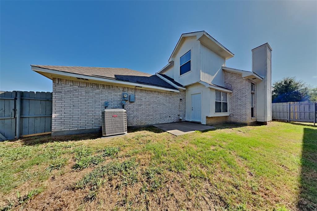921 Mossberg Lane Mesquite, TX 75181 - Photo 15 of 17 Rear view of house featuring brick siding, a patio, a shingled roof, and a chimney