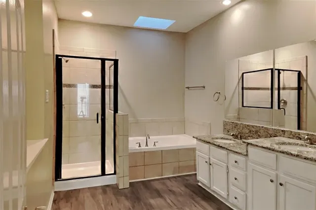 a bathroom with a granite countertop sink mirror and bathtub