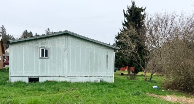 1017 C Street Vader, WA 98593 - Photo 5 of 16 a house with lots of trees in the background