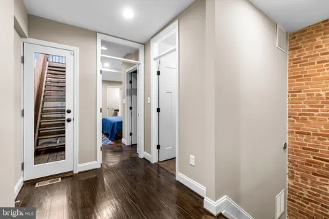 a view of a hallway with wooden floor and entryway