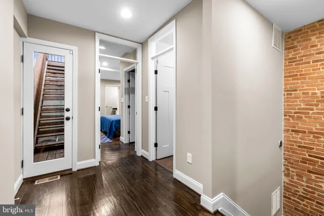 a view of a hallway with wooden floor and entryway