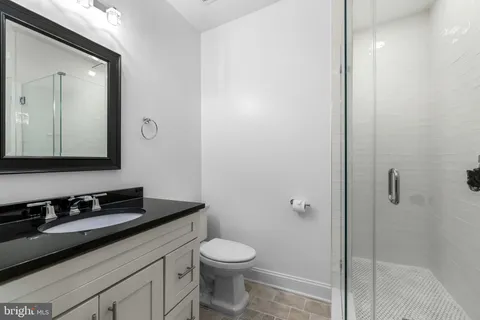 a bathroom with a granite countertop sink toilet and shower