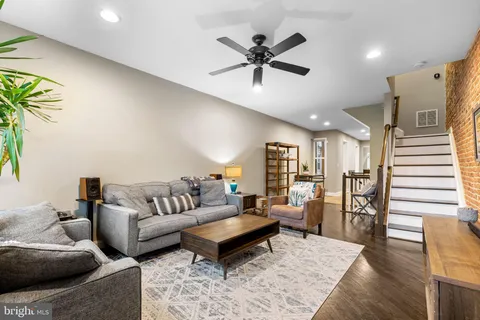 a living room with furniture and a wooden floor
