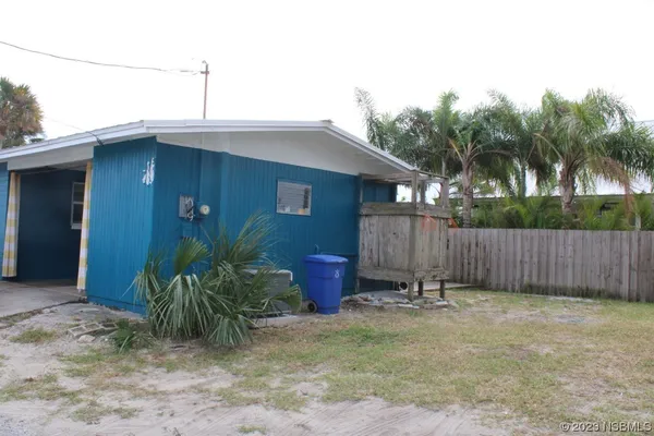 a backyard of a house with potted plants and wooden fence