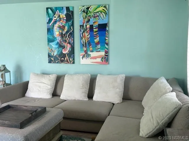 a living room with furniture and wall paintings