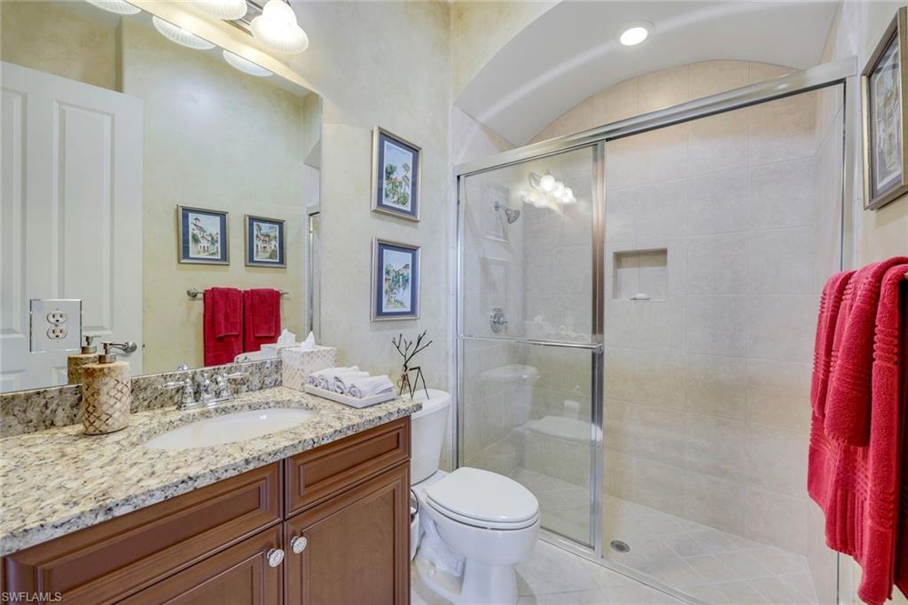 8993 Crooked Stick Court Naples, FL 34113 - Photo 14 of 24 a bathroom with a granite countertop sink a toilet and shower