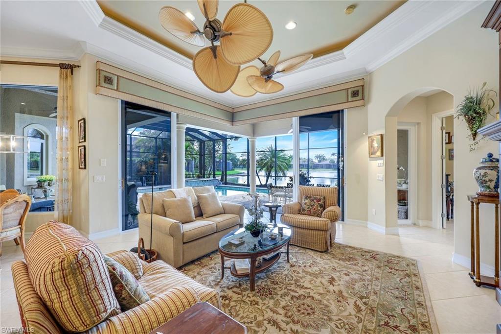 8993 Crooked Stick Court Naples, FL 34113 - Photo 5 of 24 a living room with furniture ceiling fan and a rug