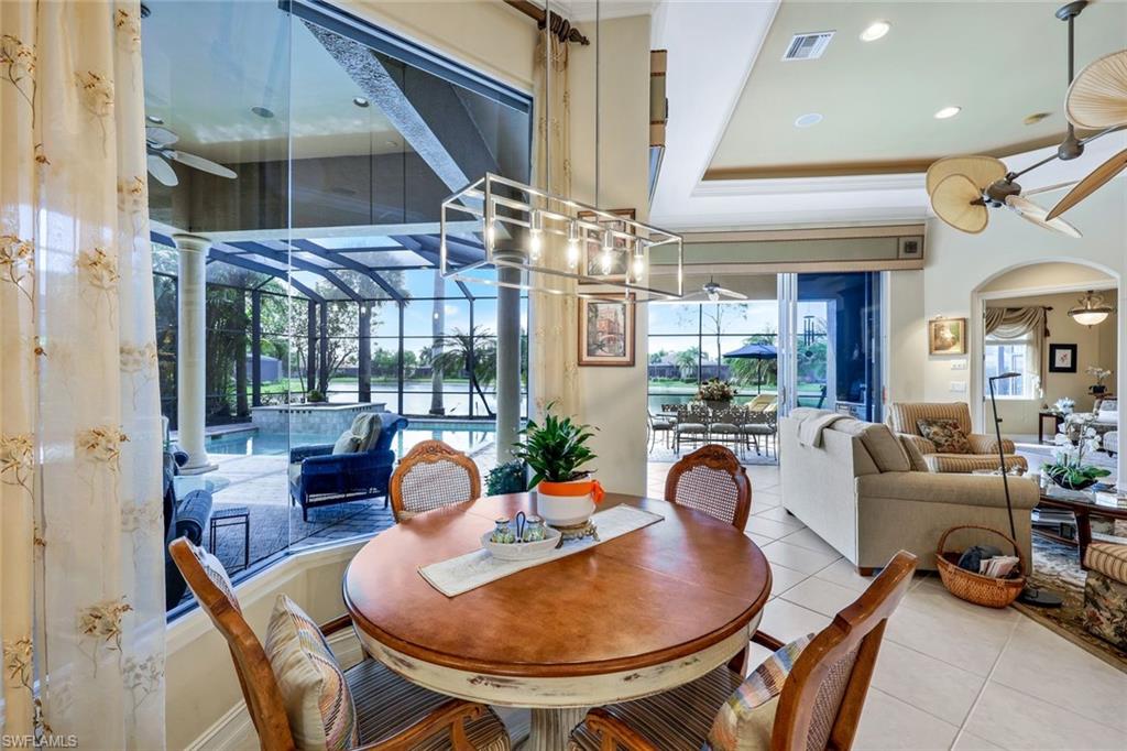 8993 Crooked Stick Court Naples, FL 34113 - Photo 7 of 24 a dining room with furniture and a chandelier