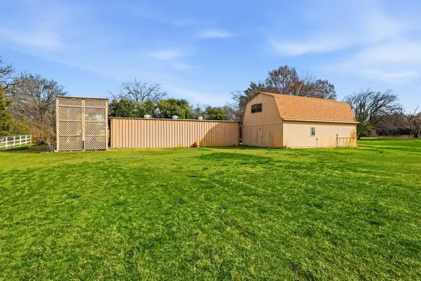 a view of a big house with a big yard and large trees