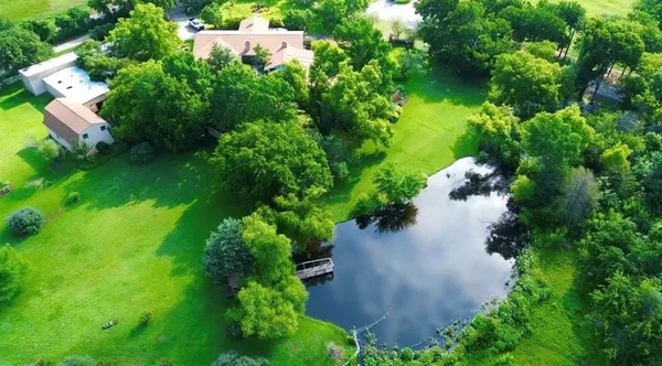 an aerial view of a house with a yard and lake view
