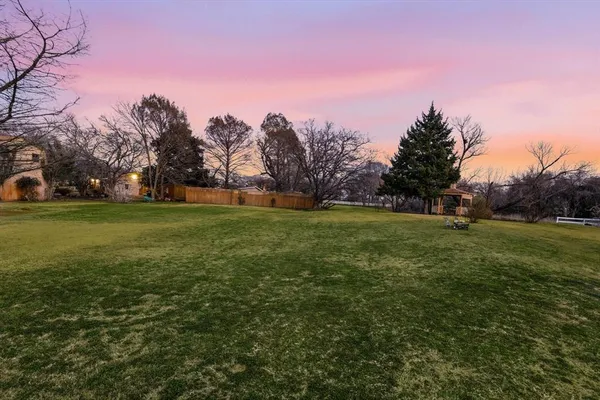 a view of a field with trees in the background