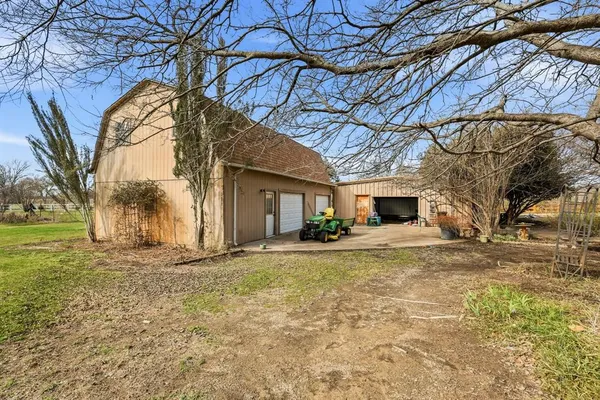 a view of a house with a yard and large tree