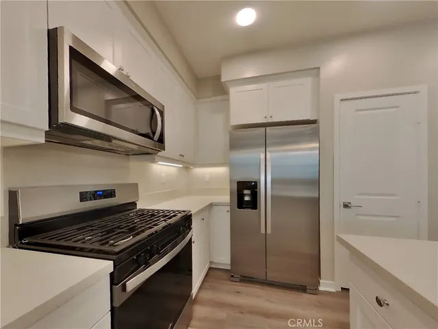 a kitchen with stainless steel appliances granite countertop a stove microwave and a refrigerator