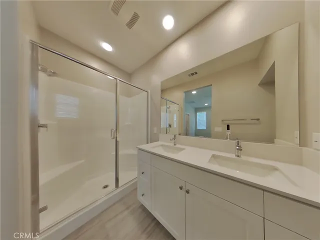 a bathroom with a shower sink and mirror