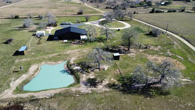 an aerial view of a house with a yard and lake