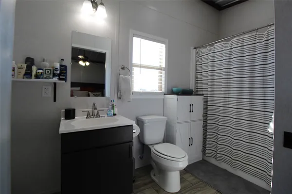 a bathroom with a toilet a sink and mirror