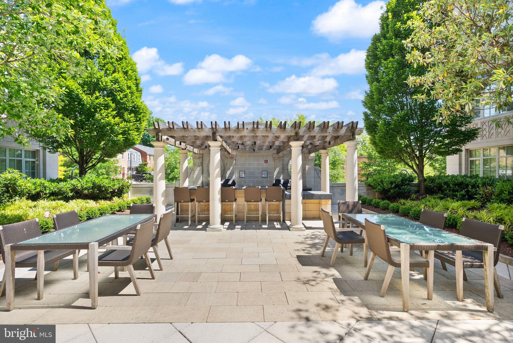 6900 Fleetwood Road, Unit 415 McLean, VA 22101 - Photo 46 of 51 a view of a patio with dining table and chairs with a large tree