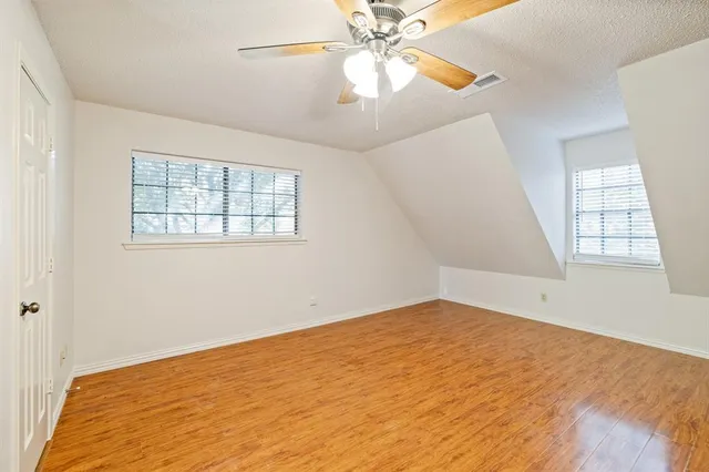 an empty room with windows and fan
