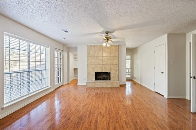 wooden floor fireplace and windows in an empty room
