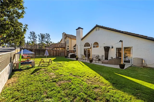a view of a white house with a big yard and large trees