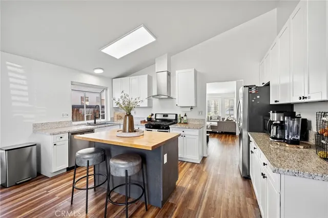 a kitchen with stainless steel appliances kitchen island granite countertop a sink and cabinets
