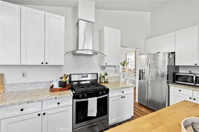 a kitchen with stainless steel appliances a stove a refrigerator and cabinets