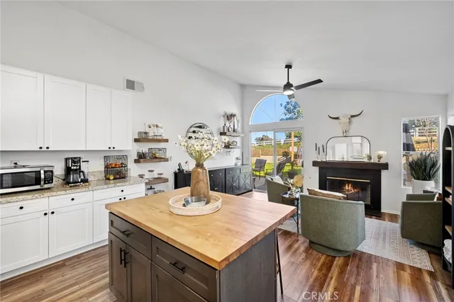 a kitchen with a sink dishwasher a microwave oven a stove and a dining table with wooden floor