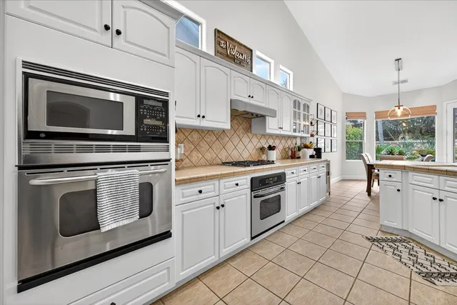 a kitchen with granite countertop cabinets stainless steel appliances and a counter space
