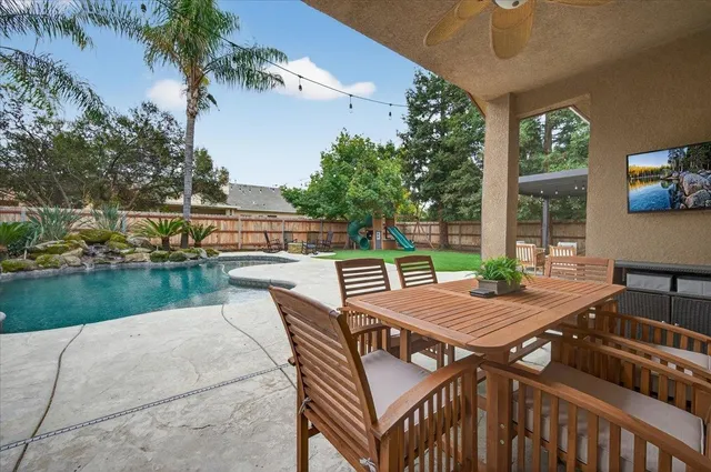 a view of a patio with table and chairs with wooden floor and fence