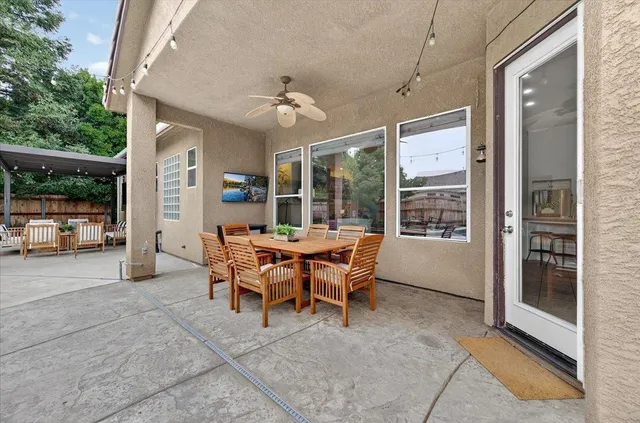 a aerial view of a white house with large windows and potted plants