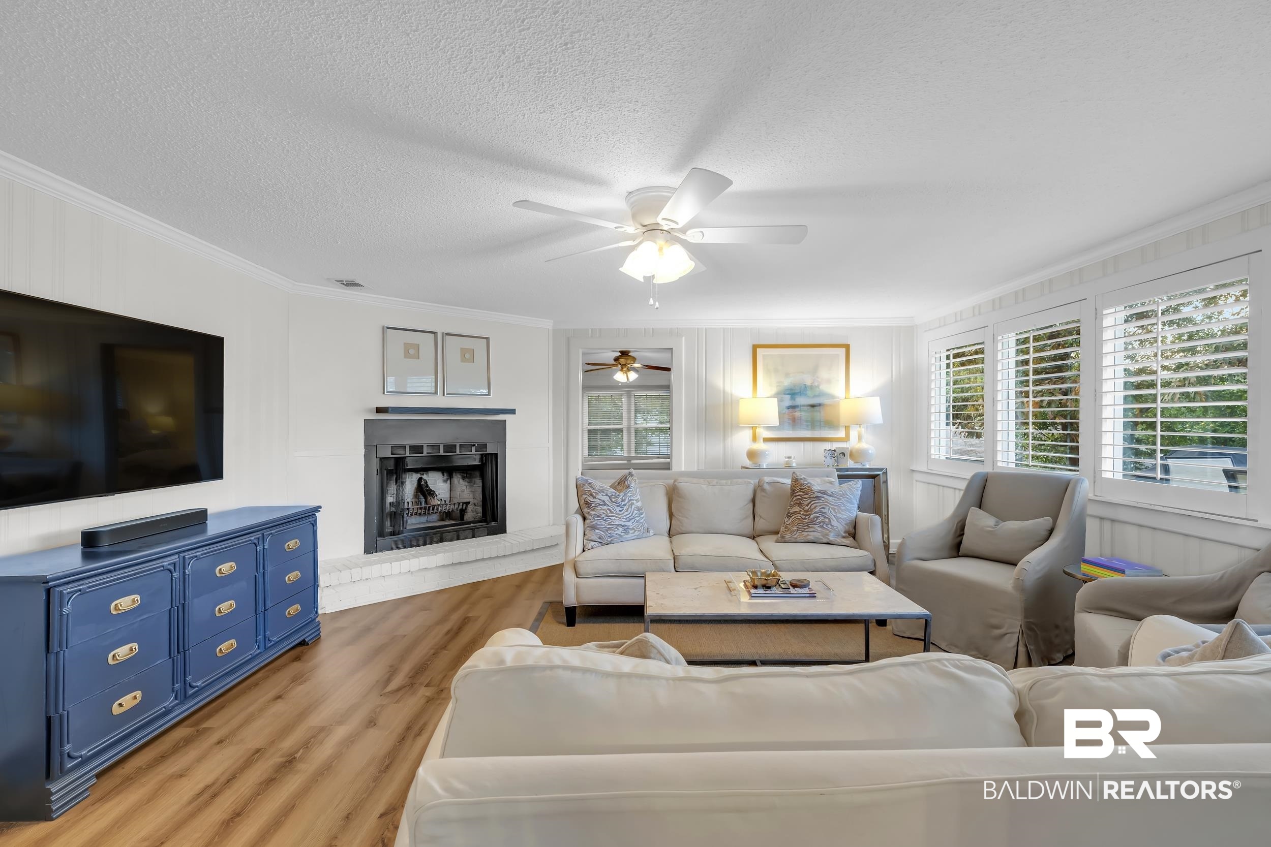 18 York Place Mobile, AL 36608 - Photo 5 of 27 Living room with ornamental molding, light wood-style floors, a textured ceiling, a fireplace with raised hearth, and ceiling fan