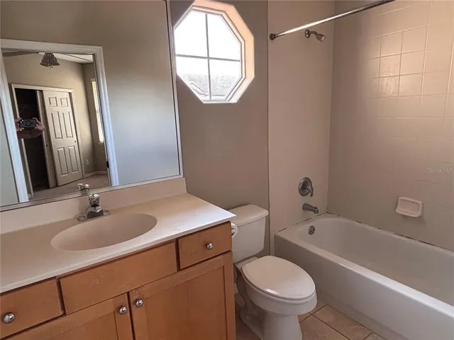 an empty room with windows and ceiling fan