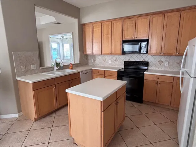 a kitchen with a sink stove top oven and cabinets
