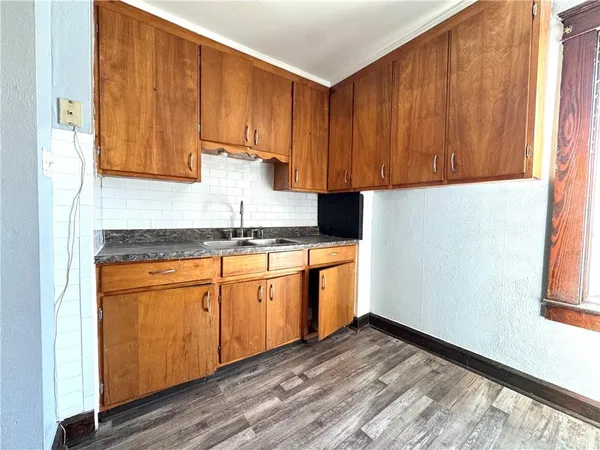 a kitchen with granite countertop wooden cabinets and a sink