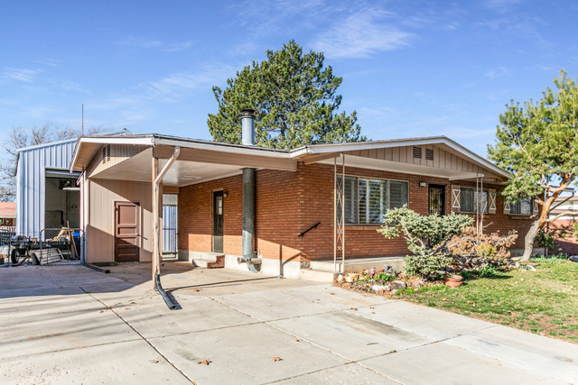 2001 North 400 West Sunset, UT 84015 - Photo 1 of 1 View of front facade featuring an attached carport, brick siding, and concrete driveway