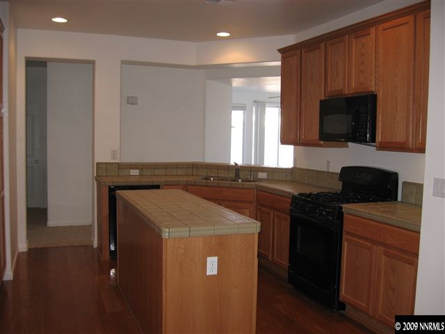 491 Alysheba Court Reno, NV 89521 - Photo 4 of 9 a kitchen with a sink and a stove top oven with wooden floor