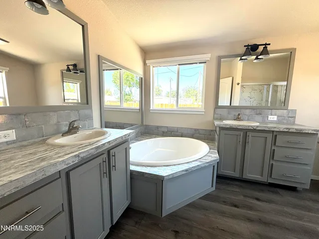 a spacious bathroom with a granite countertop bathtub sink vanity and mirror