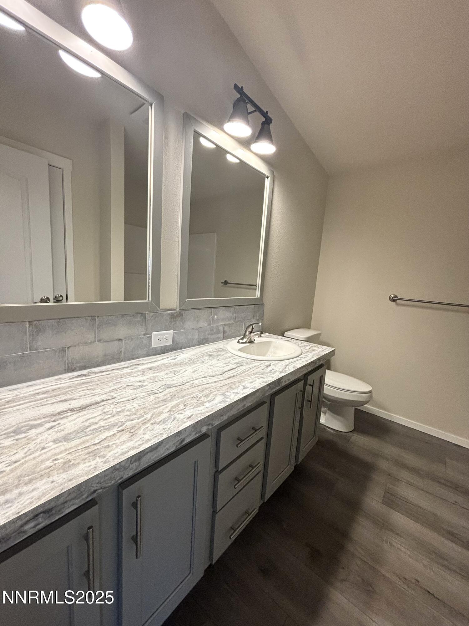 750 16th Street Lovelock, NV 89419 - Photo 16 of 17 a bathroom with a granite countertop sink a toilet a large mirror and vanity