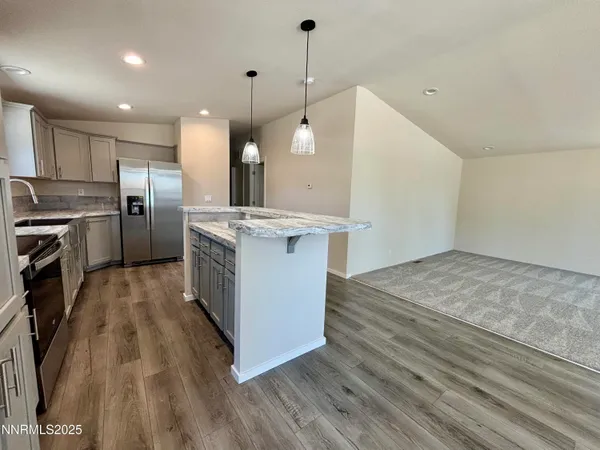 a open kitchen with a stove a sink dishwasher a refrigerator and a fireplace with wooden floor