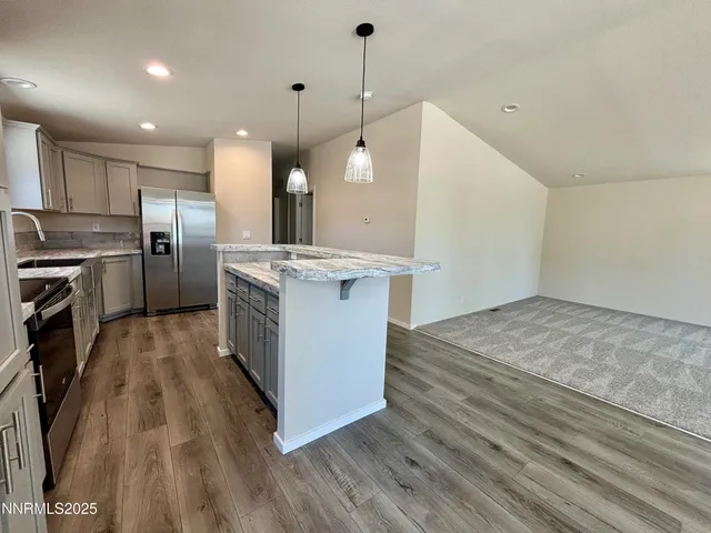 a open kitchen with a stove a sink dishwasher a refrigerator and a fireplace with wooden floor