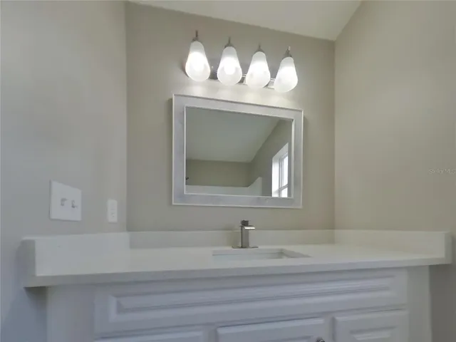 a bathroom with a sink mirror and vanity