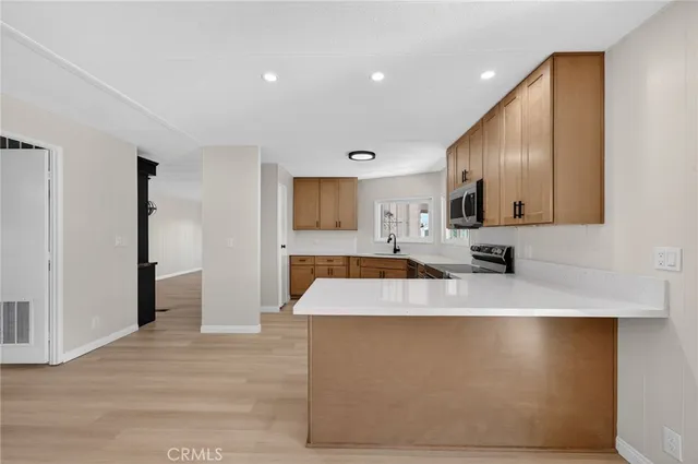 an empty room with wooden floor ceiling fan and windows
