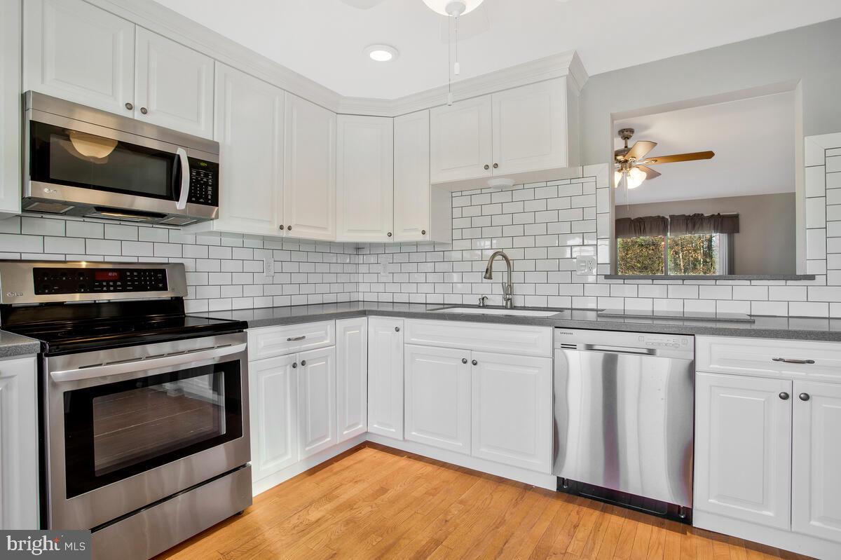 4 Offspring Court Perry Hall, MD 21128 - Photo 3 of 38 a kitchen with granite countertop white cabinets stainless steel appliances and a sink