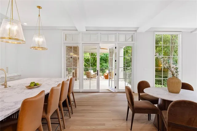 a view of a dining room and livingroom with furniture wooden floor a chandelier