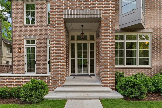 a view of a brick house with a large windows and plants