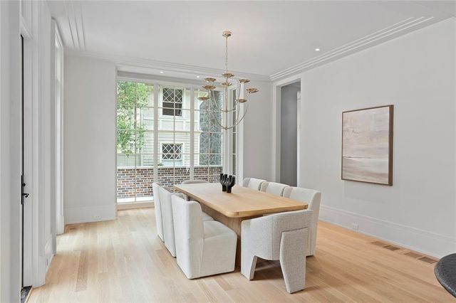 a living room with stainless steel appliances granite countertop furniture and a chandelier