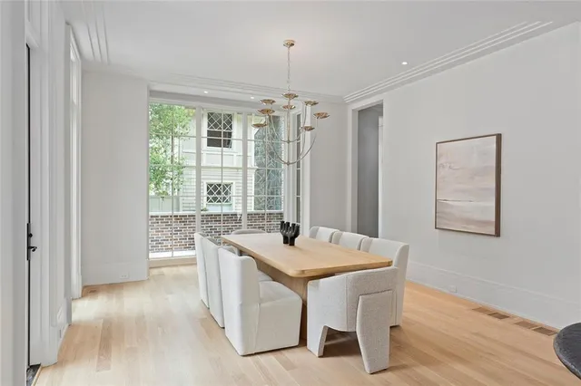 a living room with stainless steel appliances granite countertop furniture and a chandelier