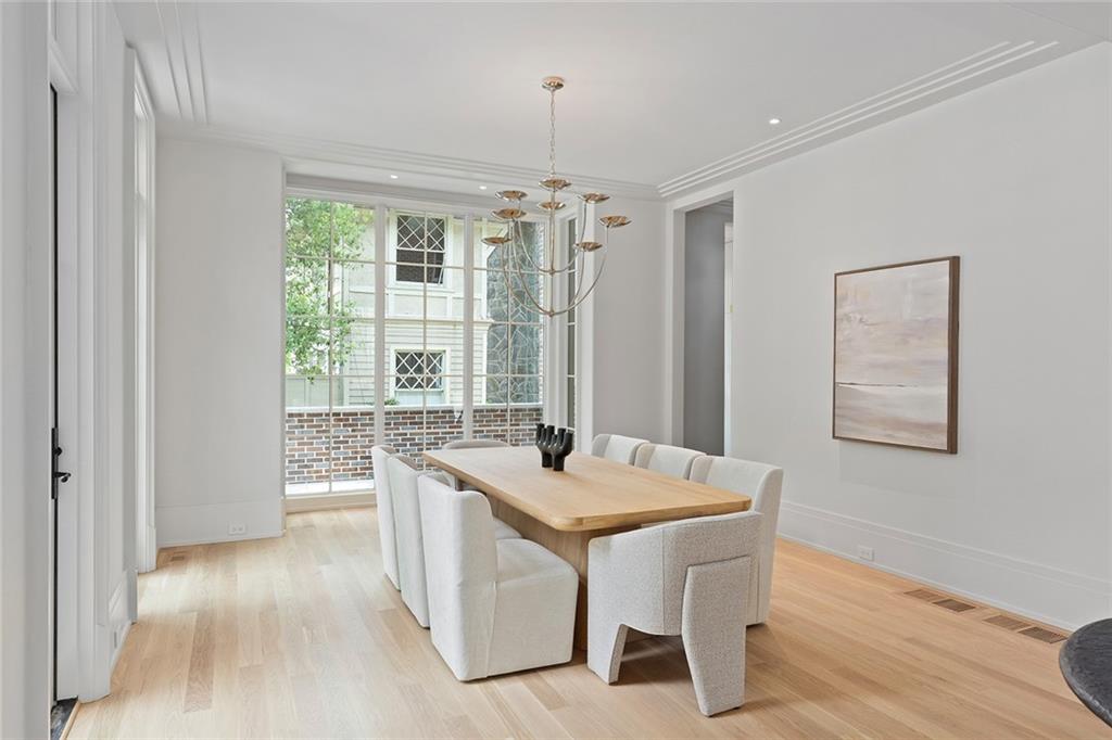 27 Maddox Drive Northeast Atlanta, GA 30309 - Photo 9 of 60 a dining room with wooden floor a chandelier a wooden table and chairs